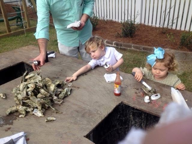 Young children learning to eat oysters at a traditional South Carolina oyster roast.
